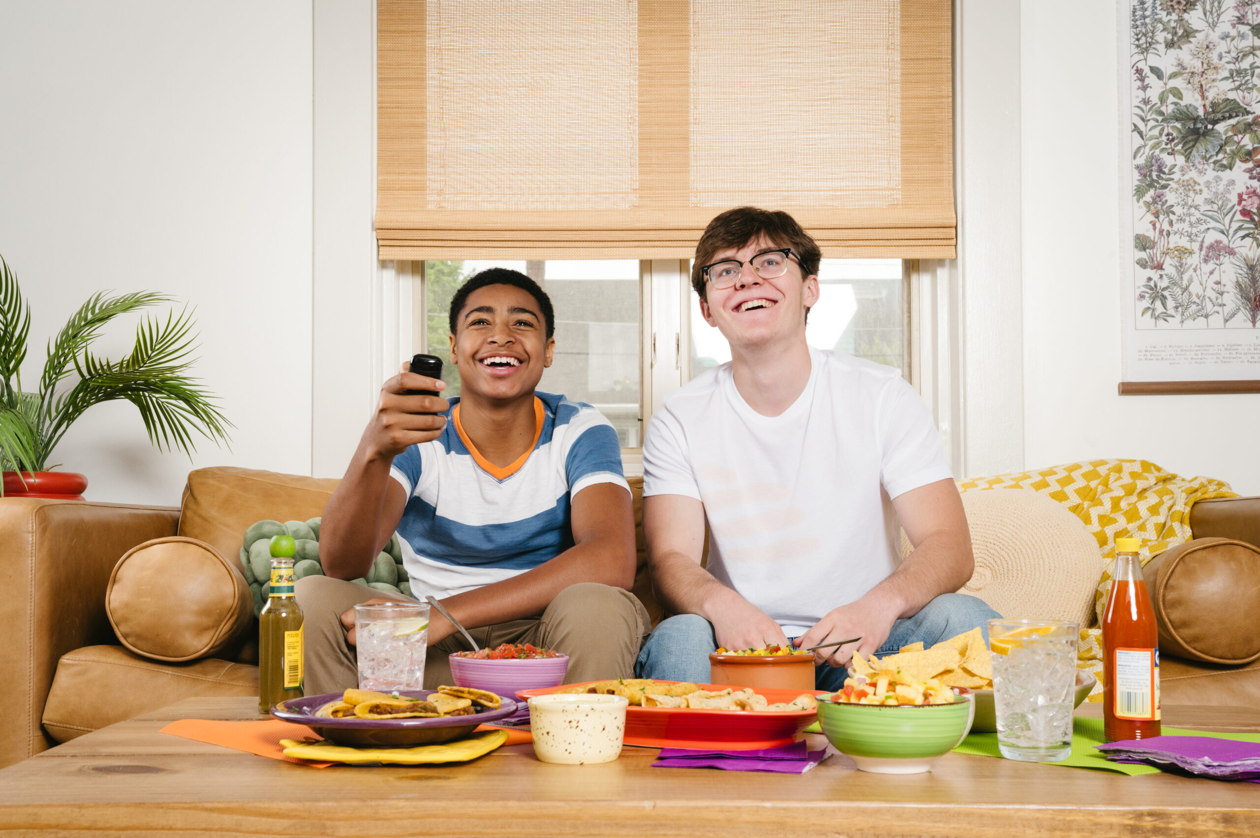 Friends enjoying José Olé taquitos while watching together